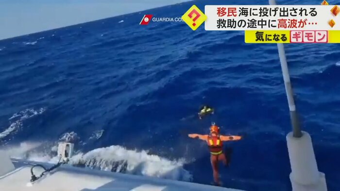 移民を救助するため、隊員が海に飛び込む