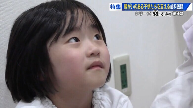 座り込んだ状態で治療台を見上げるあさひちゃん