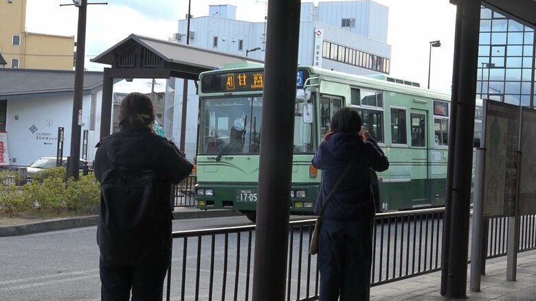 バスの写真を撮る人々