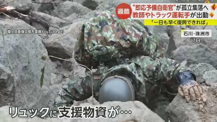 崩れた急斜面をよじ登る自衛隊員