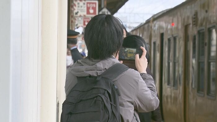 米子駅のホームで115系を撮影する鉄道ファン