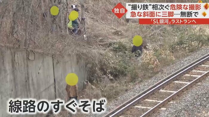 線路のすぐそばを歩く2人の男性
