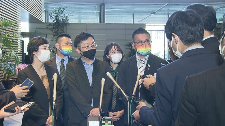 記者団の取材に応じる支援団体メンバー（首相官邸・17日）