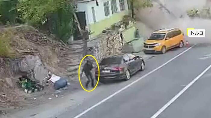 黄色い車の陰から慌てて逃げた人