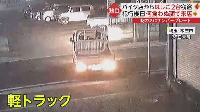 バイクショップの前の駐車スペースに停車する軽トラック