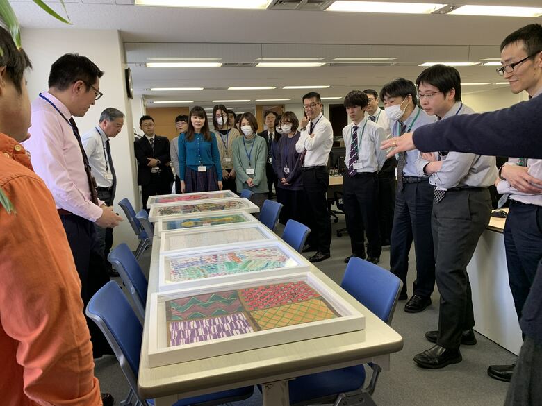 絵の説明を熱心に聞くサンネットの社員たち
