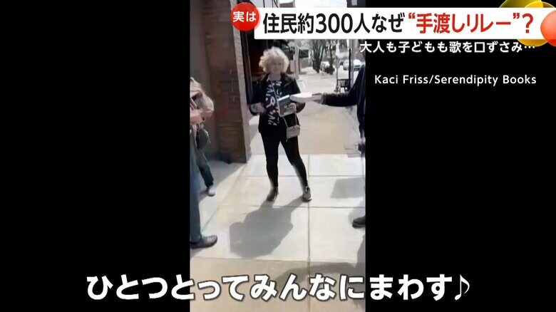 「ひとつとってみんなにまわす」と歌を口ずさむ地元住民