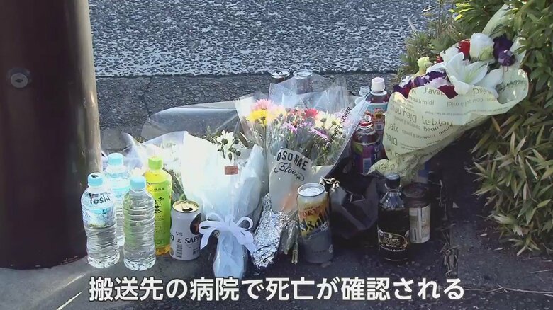 事故現場の交差点には、花などが供えられている