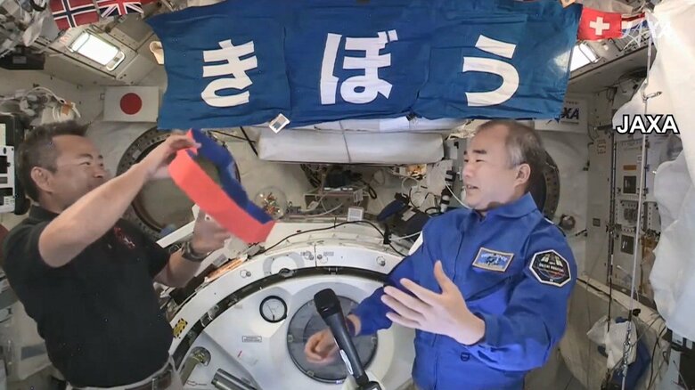 野口さんから赤いたすきが渡され笑顔で引き継ぎ