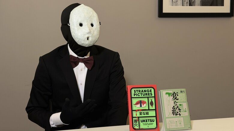 作品の評価に加え、白い仮面と黒い全身タイツという独特な見た目も注目されている