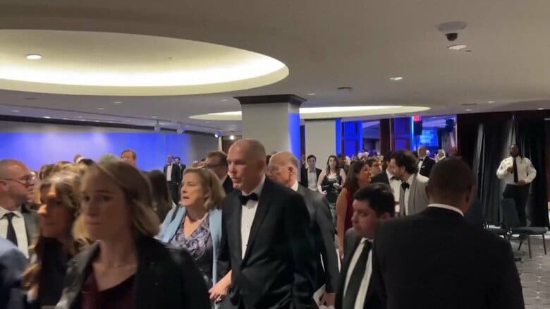 会場から避難する出席者たち