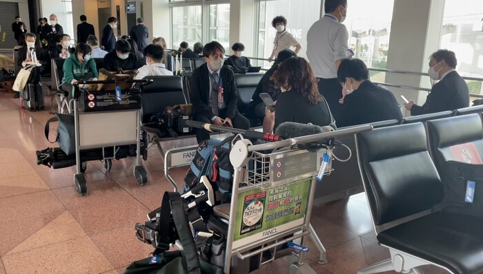 政府専用機の出発を待つ同行記者団(11日)