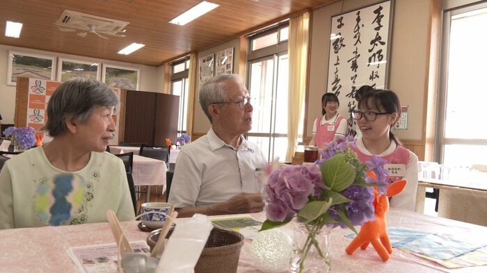 利用客と笑顔で接する生徒(右)