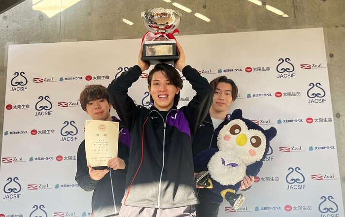 優勝カップを掲げる明治大学主将の大島