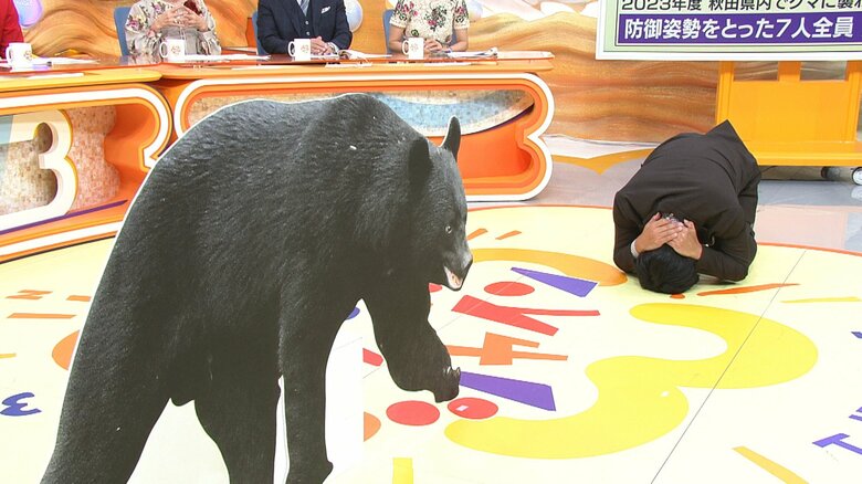 防御姿勢を実演する渡辺和洋アナウンサー