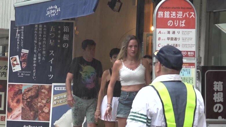 箱根町で雨宿りする外国人観光客