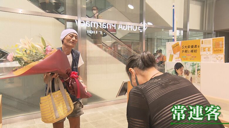 店員に花束を手渡す常連客