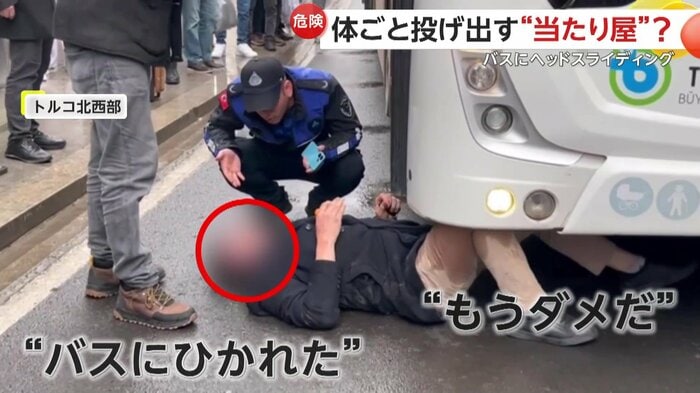 バスの足元で寝転がる男と駆け付けた救助隊員(IHA)