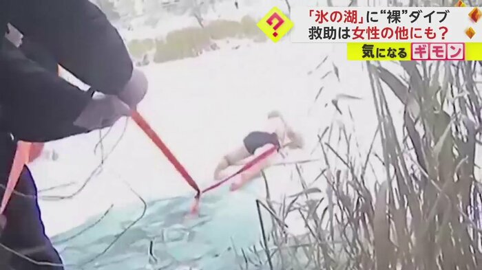 女性を救うため、氷の上を上半身裸ではうように進む警察官