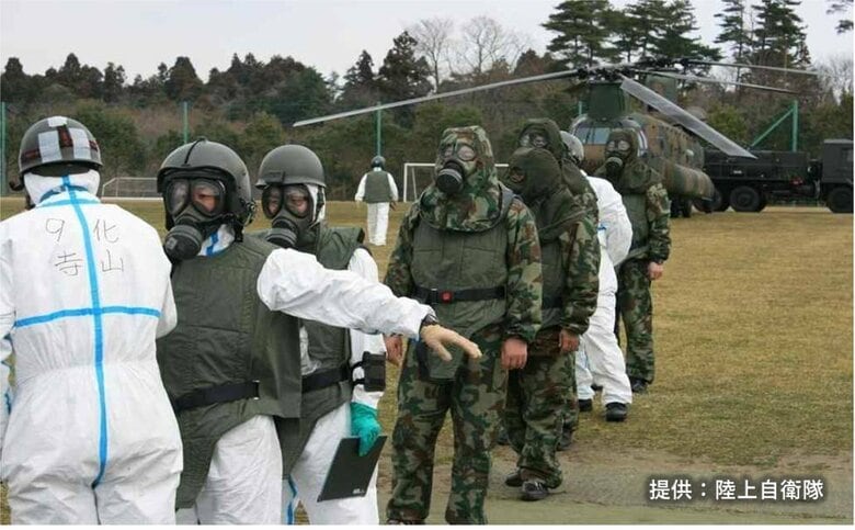 ヘリに乗り込む自衛隊員はガスマスク姿だ　2011年3月
