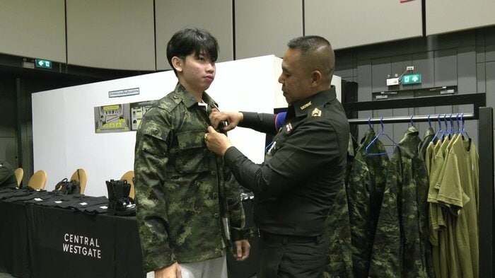 くじを引かずに志願し、迷彩服に袖を通す若者