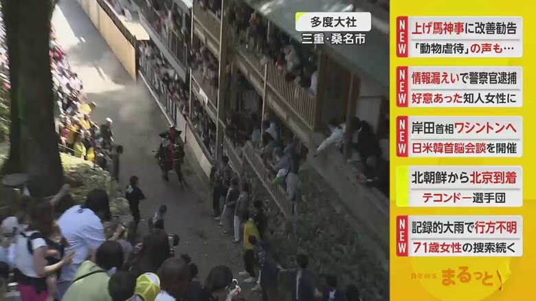 多くの見物客が道路の両脇で見守っている