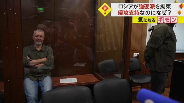 透明な仕切りの向こうに座る人物