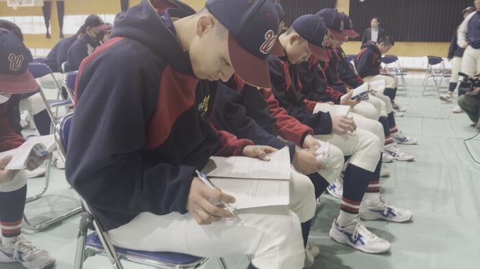 勉強しながら発表を待つ選手たち