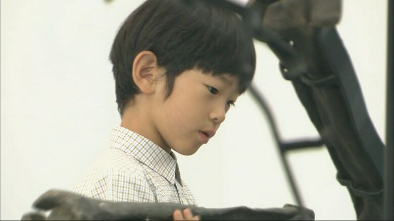 恐竜の骨のレプリカを手にされる悠仁さま