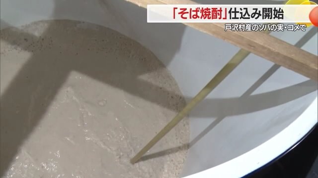 長い棒の先に板がついた道具でかき回す