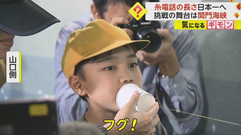 「フグ！」と糸電話に向かって話す小学生