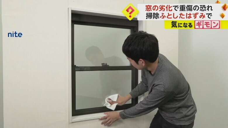 窓の拭き掃除をする男性