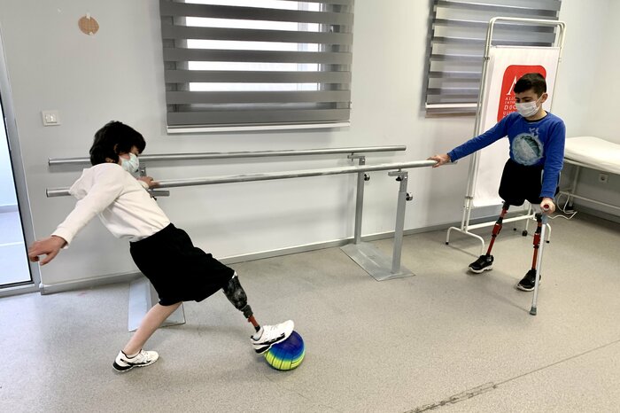 新しい義足をつけてサッカーをする2人