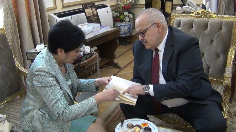 50年前の教科書を手に、カイロ大の学長と談笑する小池知事(6日)