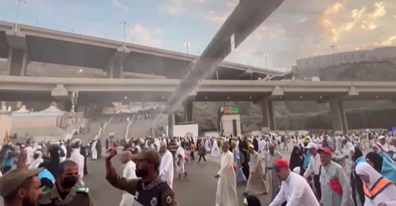 暑さ対策のミストをくぐる巡礼者