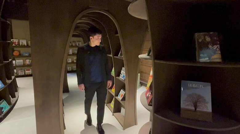 「えほんのどうくつ」を歩くJALふるさと応援隊の牧内健将さん