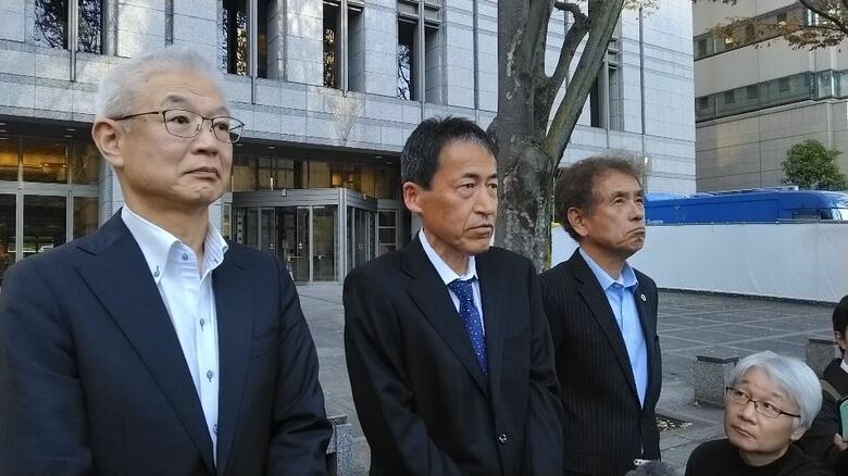 控訴審の後に取材に応じる田原義則さん（中央）