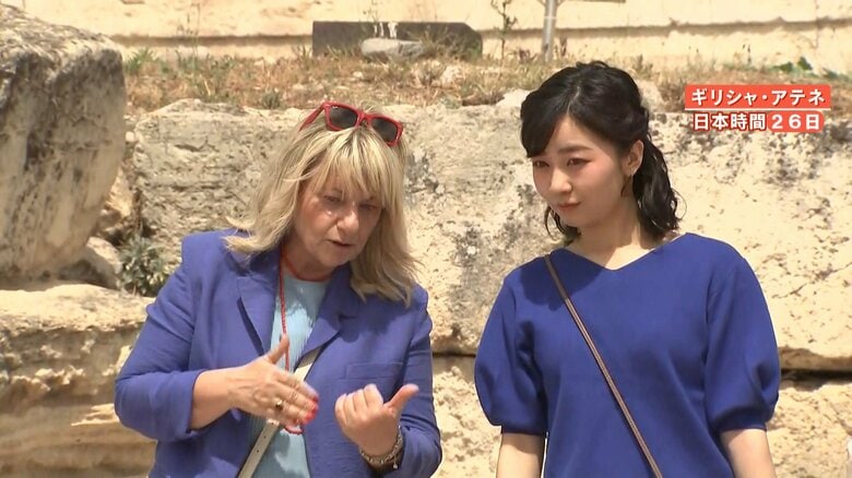 首元がV字になったブルーのニットを着用