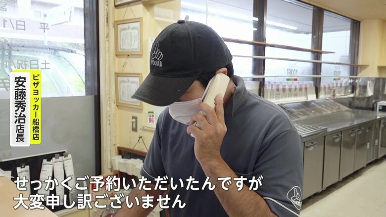 予約をしていた客にキャンセルの電話を入れる店長