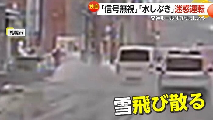 歩道に勢いよく飛び散っているタイヤがはねた雪(札幌スパローマン)