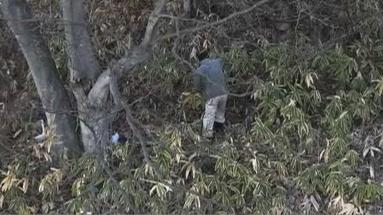 ドローン映像　斜面を登ろうとしている高齢男性の姿が