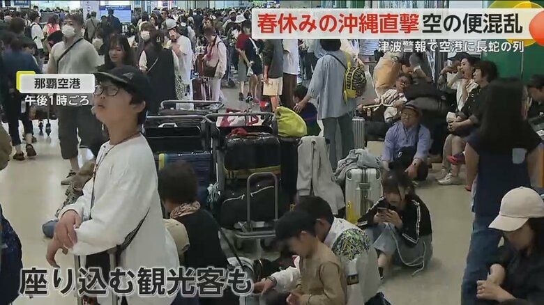 那覇空港で一時全便が欠航となり、疲れて座り込む観光客らの姿