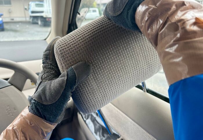ヘッドレストの棒を窓枠に差し込む（特集班撮影）