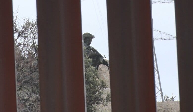 メキシコ側では武装した軍人が国境の壁周辺を警戒していた
