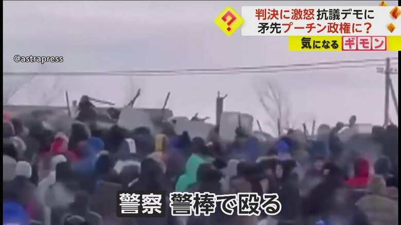 警棒を振り上げる警察官たちと市民