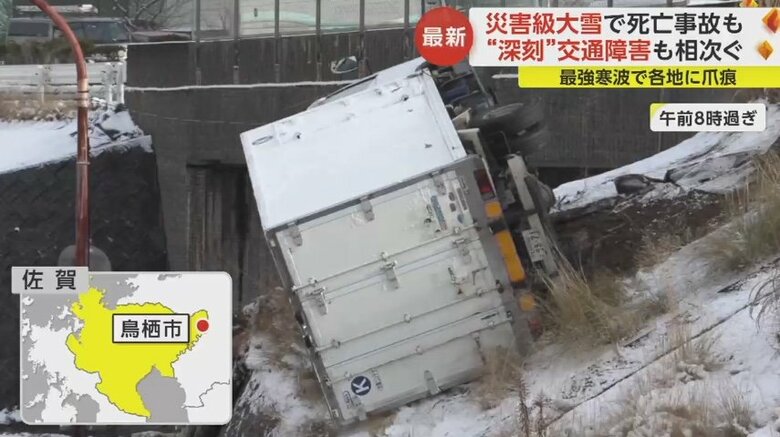 トラックが現道のガードレールを突き破り、道路脇の斜面に横転