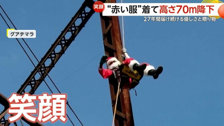 笑顔で70メートルの橋の上から降下するサンタクロース