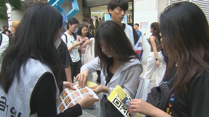 期日前投票に行かないよう訴える若者たち(29日撮影)