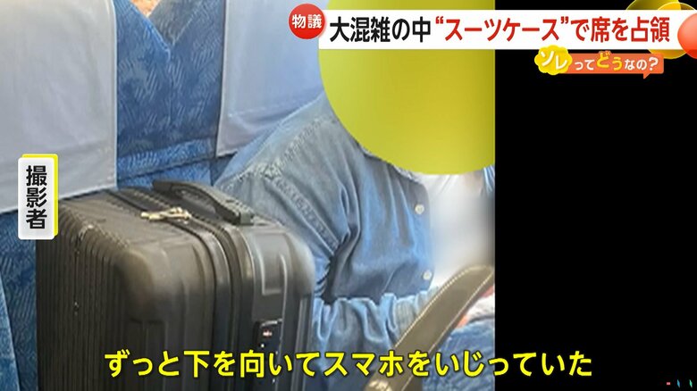 座席にスーツケースを乗せ、席を占領する男性