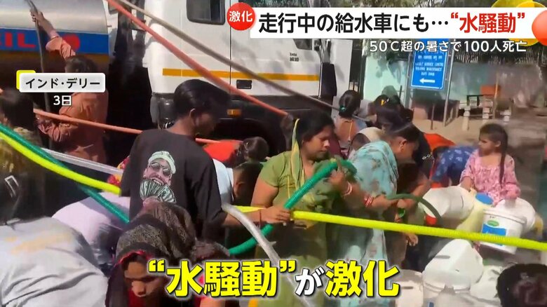 給水車に駆け寄りホースを伸ばして給水を行う住民たち